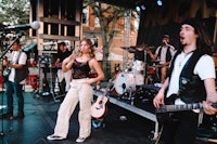 a group of people on stage at an outdoor concert